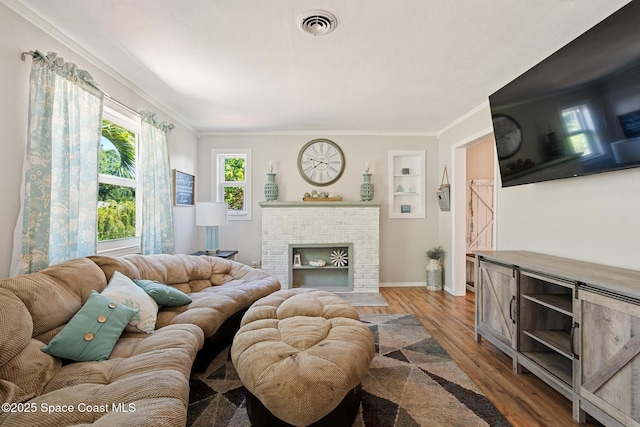 1949 36th Ave, Vero Beach, FL 32960 - living area featuring wood finished floors, a fireplace, ornamental molding, and built in features