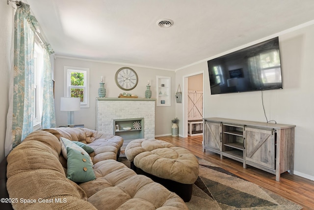1949 36th Ave, Vero Beach, FL 32960 - living room with wood finished floors, crown molding, and a fireplace