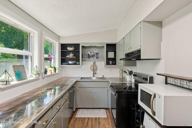 1949 36th Ave, Vero Beach, FL 32960 - kitchen with stainless steel appliances, a textured ceiling, open shelves, under cabinet range hood, and wood finished floors