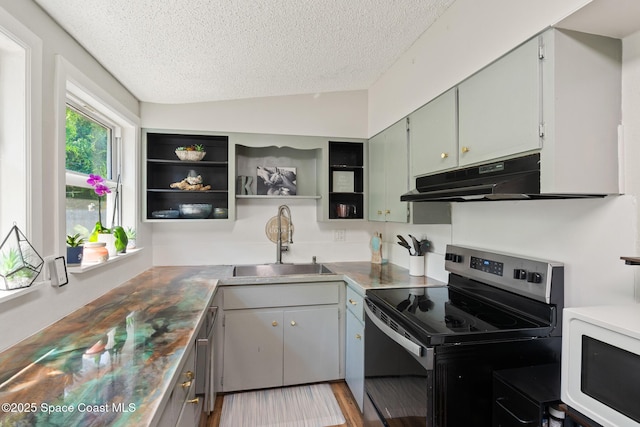 1949 36th Ave, Vero Beach, FL 32960 - kitchen featuring stainless steel range with electric stovetop, under cabinet range hood, white microwave, a textured ceiling, and open shelves