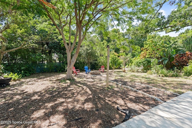 1949 36th Ave, Vero Beach, FL 32960 - view of yard featuring an outdoor fire pit and view of wooded area