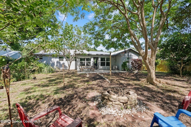 1949 36th Ave, Vero Beach, FL 32960 - back of property featuring a fire pit, a patio, and a metal roof