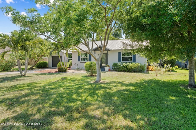 1949 36th Ave, Vero Beach, FL 32960 - ranch-style house featuring stucco siding, a front lawn, an attached garage, and a metal roof