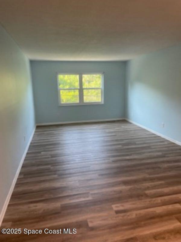 230 Columbia Dr Unit 208, Cape Canaveral, FL 32920 - empty room featuring wood finished floors and baseboards