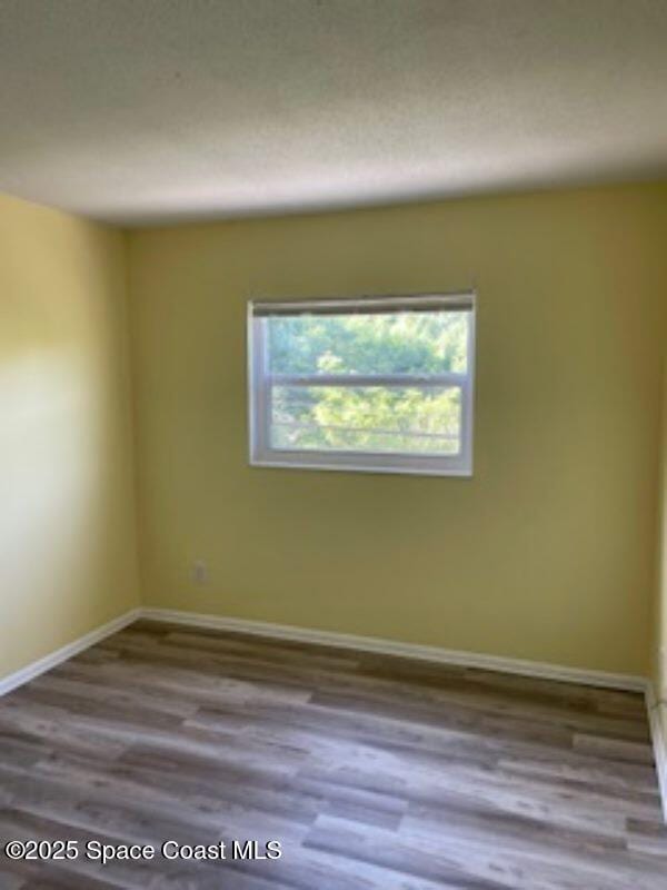 230 Columbia Dr Unit 208, Cape Canaveral, FL 32920 - empty room featuring wood finished floors and baseboards