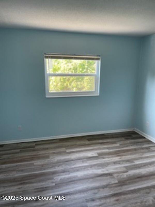 230 Columbia Dr Unit 208, Cape Canaveral, FL 32920 - spare room featuring wood finished floors and baseboards