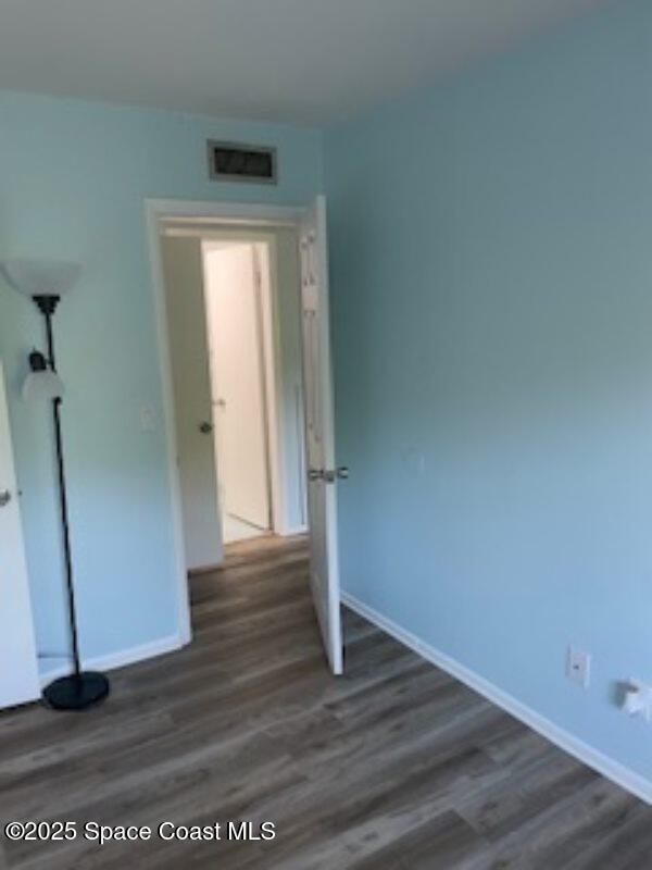 230 Columbia Dr Unit 208, Cape Canaveral, FL 32920 - unfurnished bedroom with dark wood finished floors and baseboards