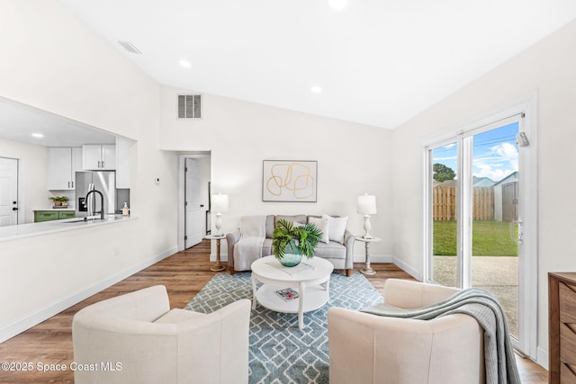 865 Southern Pine Trl, Rockledge, FL 32955 - living area featuring wood finished floors, vaulted ceiling, and recessed lighting