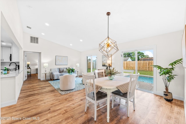 865 Southern Pine Trl, Rockledge, FL 32955 - dining room with light wood-type flooring, lofted ceiling, and recessed lighting