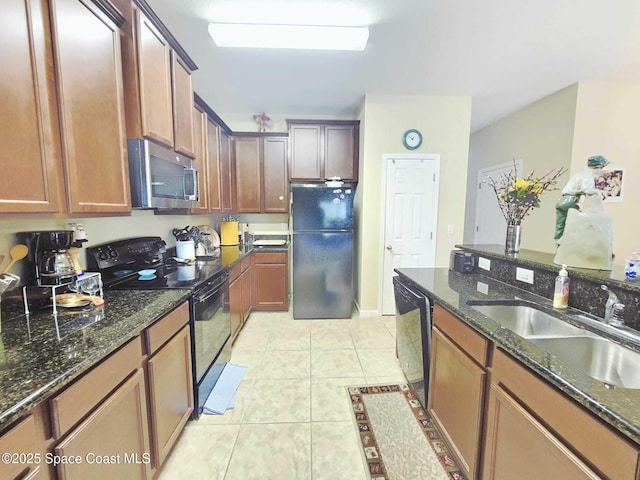 2735 Revolution St Unit 101, Melbourne, FL 32935 - kitchen featuring black appliances, dark stone counters, and light tile patterned flooring