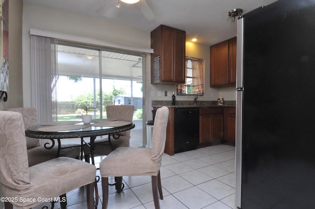 2938 Chipper Dr NE, Palm Bay, FL 32905 - kitchen with freestanding refrigerator, black dishwasher, ceiling fan, light tile patterned flooring, and brown cabinetry