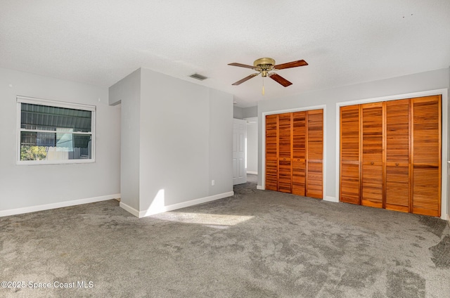 1250 Admiralty Blvd, Rockledge, FL 32955 - unfurnished bedroom with two closets, carpet floors, ceiling fan, and a textured ceiling