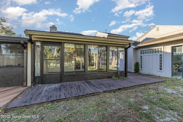 1250 Admiralty Blvd, Rockledge, FL 32955 - back of house featuring a sunroom, a chimney, and a deck