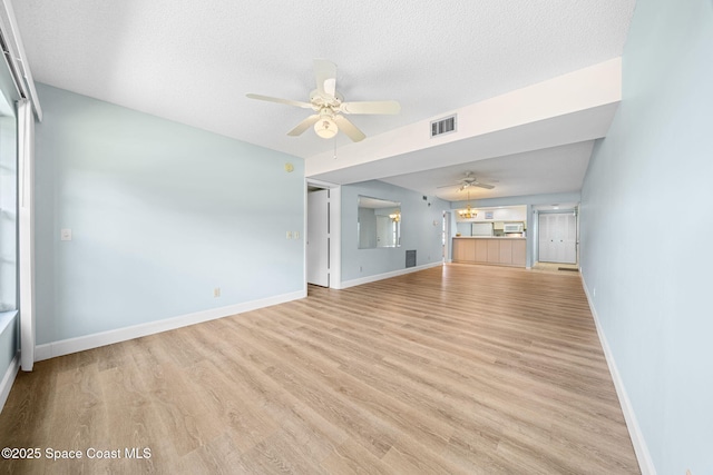 14 Plantation Dr Unit 103, Vero Beach, FL 32966 - unfurnished living room with ceiling fan, light wood finished floors, and a textured ceiling