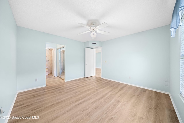 14 Plantation Dr Unit 103, Vero Beach, FL 32966 - unfurnished bedroom with light wood-style flooring, connected bathroom, ceiling fan, and a textured ceiling