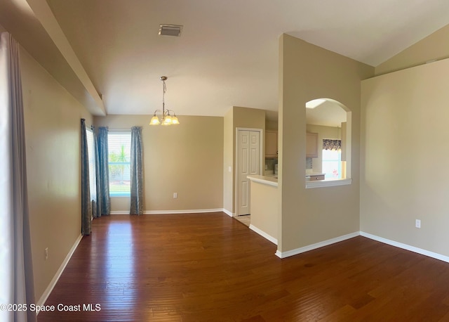 2324 Addington Cir, Rockledge, FL 32955 - empty room featuring lofted ceiling, a chandelier, dark wood-style flooring, and arched walkways