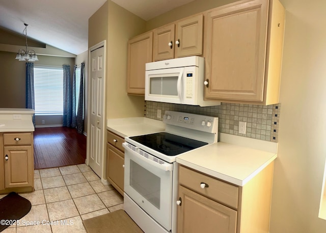 2324 Addington Cir, Rockledge, FL 32955 - kitchen with white appliances, vaulted ceiling, decorative backsplash, light countertops, and light tile patterned floors