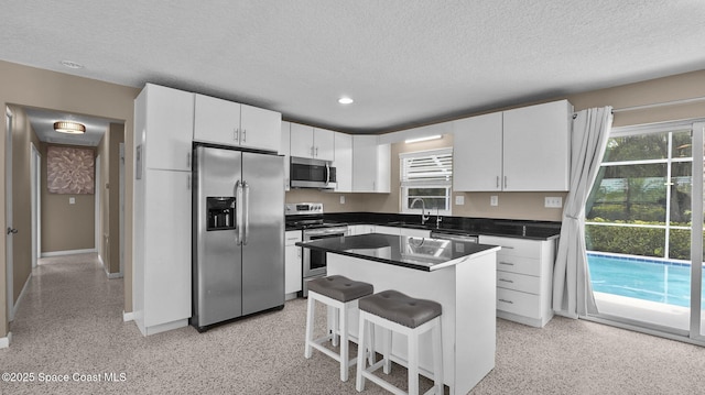 2009 Vaughn St, Titusville, FL 32796 - kitchen featuring appliances with stainless steel finishes, a textured ceiling, dark countertops, recessed lighting, and white cabinets