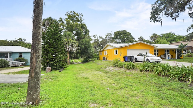 2009 Vaughn St, Titusville, FL 32796 - view of green lawn featuring an attached garage and concrete driveway