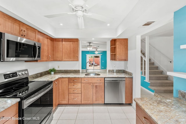 712 Sea Palm Ln, Satellite Beach, FL 32937 - kitchen with appliances with stainless steel finishes, a ceiling fan, light tile patterned floors, light stone countertops, and a tray ceiling