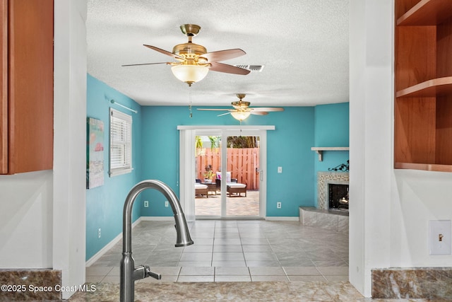 712 Sea Palm Ln, Satellite Beach, FL 32937 - interior space with a textured ceiling, a ceiling fan, a fireplace, and tile patterned floors