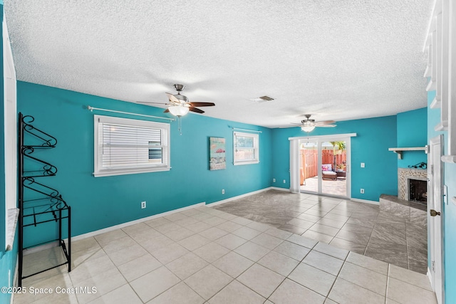 712 Sea Palm Ln, Satellite Beach, FL 32937 - unfurnished living room featuring ceiling fan, a fireplace with raised hearth, a textured ceiling, and light tile patterned floors