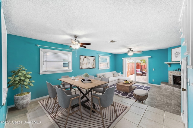 712 Sea Palm Ln, Satellite Beach, FL 32937 - tiled dining area featuring a ceiling fan, a fireplace with raised hearth, and a textured ceiling