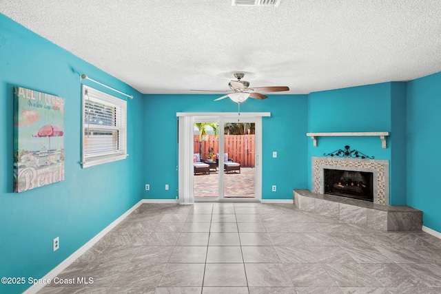 712 Sea Palm Ln, Satellite Beach, FL 32937 - unfurnished living room with ceiling fan, a tiled fireplace, and a textured ceiling
