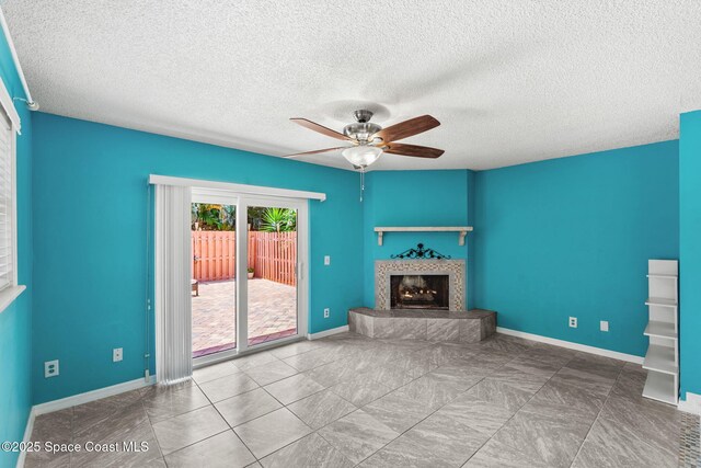 712 Sea Palm Ln, Satellite Beach, FL 32937 - unfurnished living room featuring a ceiling fan, a fireplace with raised hearth, and a textured ceiling