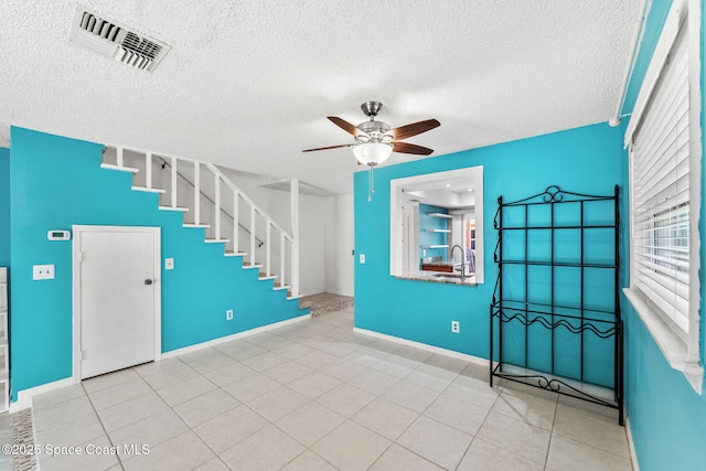 712 Sea Palm Ln, Satellite Beach, FL 32937 - tiled entryway with a ceiling fan, healthy amount of natural light, a textured ceiling, and stairs