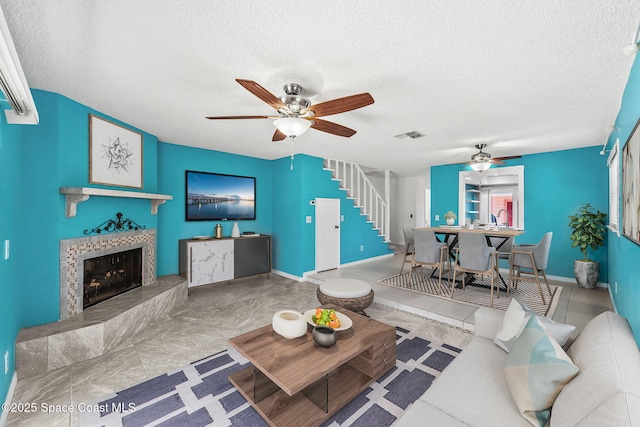 712 Sea Palm Ln, Satellite Beach, FL 32937 - living area featuring a ceiling fan, stairway, a textured ceiling, and a fireplace