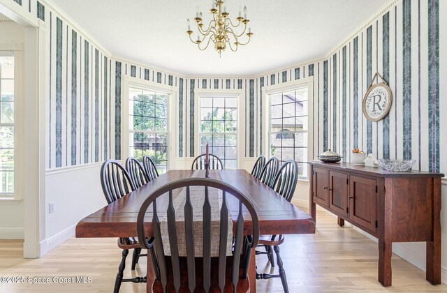 2123 Royal Oaks Dr, Rockledge, FL 32955 - dining area with light wood-style flooring, wallpapered walls, and a chandelier
