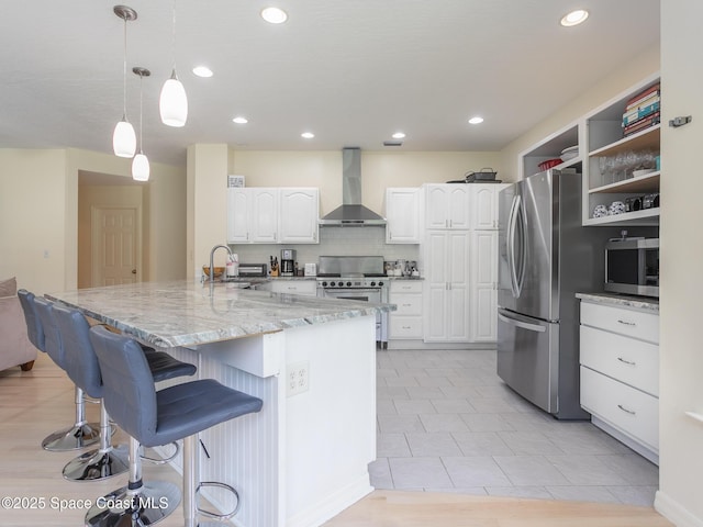 2123 Royal Oaks Dr, Rockledge, FL 32955 - kitchen with wall chimney range hood, stainless steel appliances, white cabinetry, a breakfast bar area, and light stone countertops