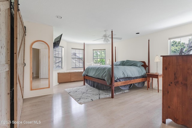 2123 Royal Oaks Dr, Rockledge, FL 32955 - bedroom featuring wood finished floors, a barn door, and ceiling fan