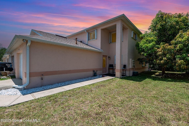 112 Plover Ln Unit 6-33, Rockledge, FL 32955 - view of side of home featuring stucco siding, a yard, a shingled roof, and a garage