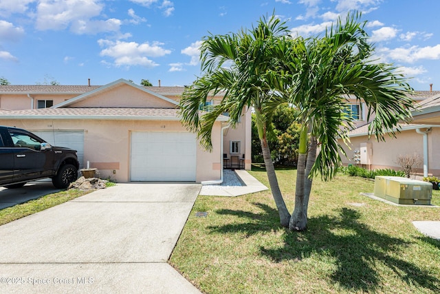 112 Plover Ln Unit 6-33, Rockledge, FL 32955 - view of front of property with stucco siding, an attached garage, concrete driveway, and a front lawn