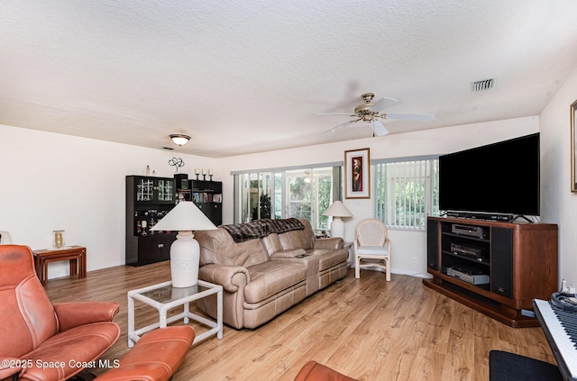 112 Plover Ln Unit 6-33, Rockledge, FL 32955 - living room with light wood-type flooring, a ceiling fan, and a textured ceiling