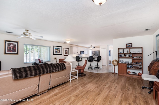 112 Plover Ln Unit 6-33, Rockledge, FL 32955 - living area with a ceiling fan, light wood finished floors, and a textured ceiling
