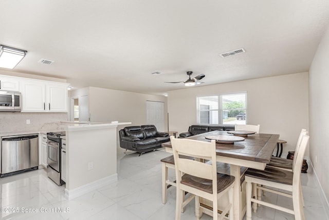 1245 Arlington Cir, Merritt Island, FL 32952 - dining room featuring light marble finish flooring and ceiling fan