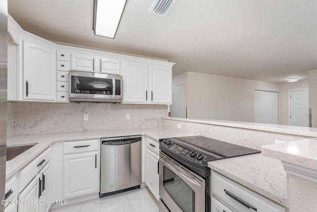 1245 Arlington Cir, Merritt Island, FL 32952 - kitchen with appliances with stainless steel finishes, light marble finish flooring, white cabinets, and light stone counters