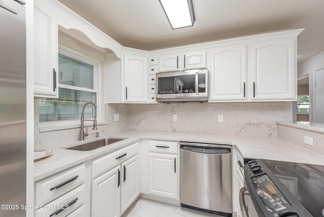 1245 Arlington Cir, Merritt Island, FL 32952 - kitchen with stainless steel appliances, white cabinets, tasteful backsplash, and light stone countertops