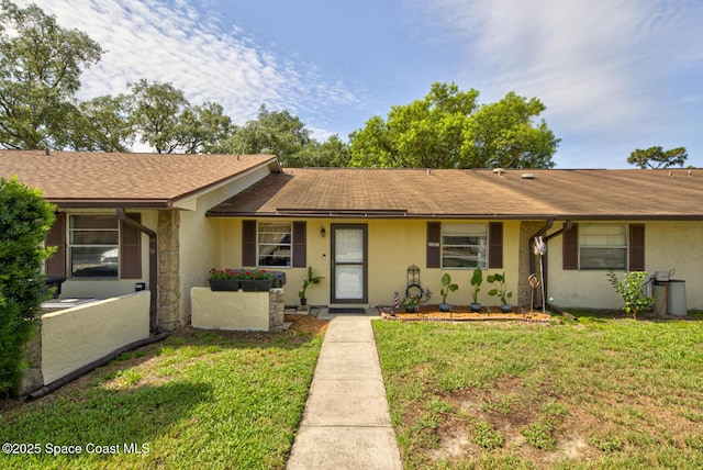 1240 Cheney Hwy Unit F, Titusville, FL 32780 - ranch-style home featuring a front yard, a shingled roof, stucco siding, and stone siding