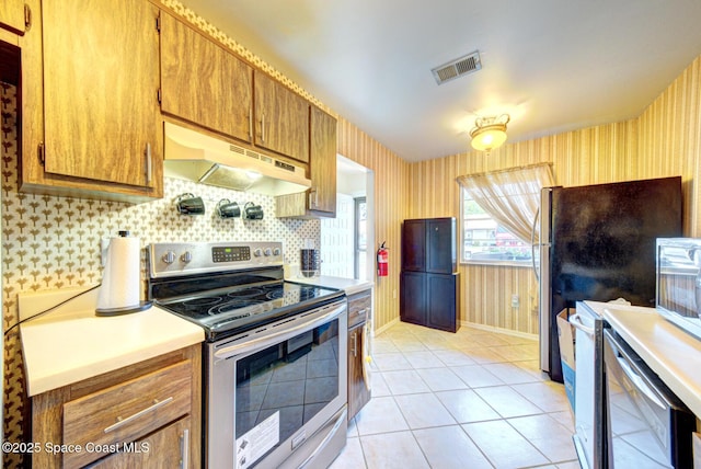 1240 Cheney Hwy Unit F, Titusville, FL 32780 - kitchen with stainless steel range with electric cooktop, under cabinet range hood, wallpapered walls, brown cabinets, and light countertops