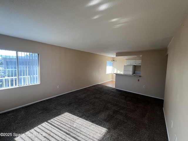 800 N Fiske Blvd Unit 613, Cocoa, FL 32922 - spare room featuring a chandelier, dark carpet, and a textured ceiling