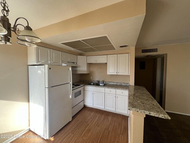 800 N Fiske Blvd Unit 613, Cocoa, FL 32922 - kitchen featuring white appliances, wood finished floors, white cabinetry, a peninsula, and a chandelier