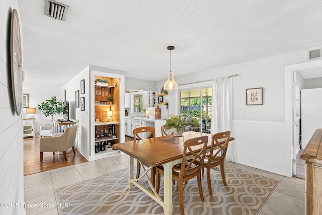 3127 Marshall Dr, Melbourne, FL 32901 - dining room with a textured ceiling, wainscoting, and light tile patterned floors