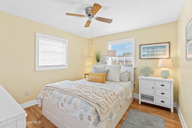 3127 Marshall Dr, Melbourne, FL 32901 - bedroom featuring light wood-style floors, a textured ceiling, and a ceiling fan