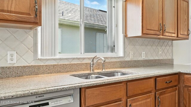 7927 Citrus Creek Dr, Melbourne, FL 32940 - kitchen with white dishwasher, light countertops, backsplash, and brown cabinets
