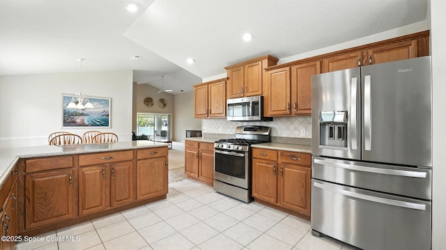7927 Citrus Creek Dr, Melbourne, FL 32940 - kitchen featuring appliances with stainless steel finishes, vaulted ceiling, brown cabinets, light countertops, and recessed lighting