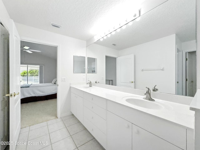 7927 Citrus Creek Dr, Melbourne, FL 32940 - bathroom with double vanity, ensuite bathroom, a textured ceiling, tile patterned floors, and ceiling fan